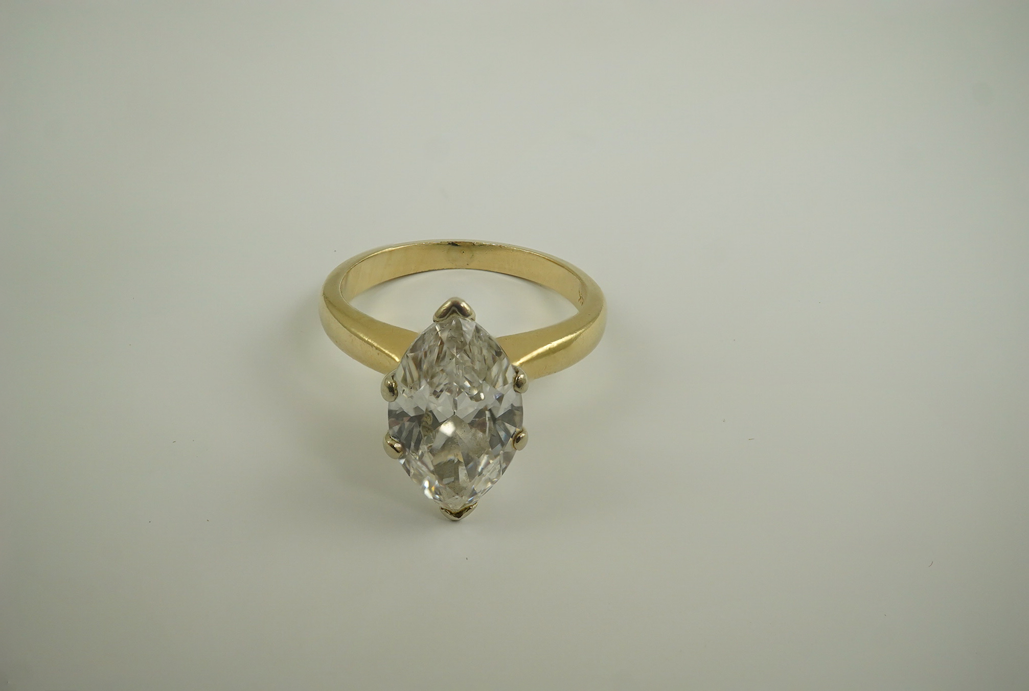 A modern 14k gold and solitaire marquise diamond set ring